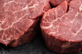 raw fillet mignon steaks in grey stone plate macro close up
