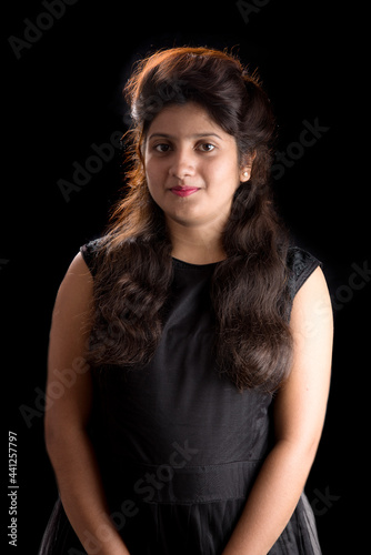 Portrait of beautiful young girl on black background