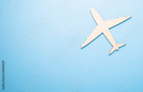 Model of a toy airplane of white color on a blue background with place for adding text, concept of air transportation, tourism, travel.