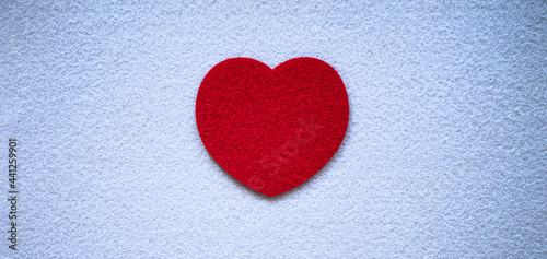 Red heart made of soft textiles on a white background. Felt blanks for needlework