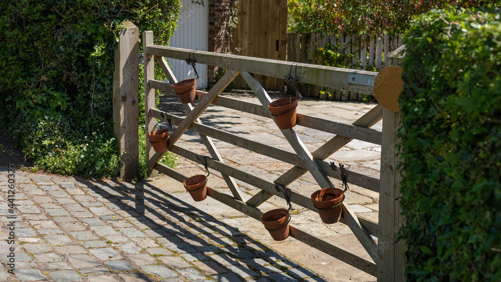 Closed wooden gate with plant pots attached