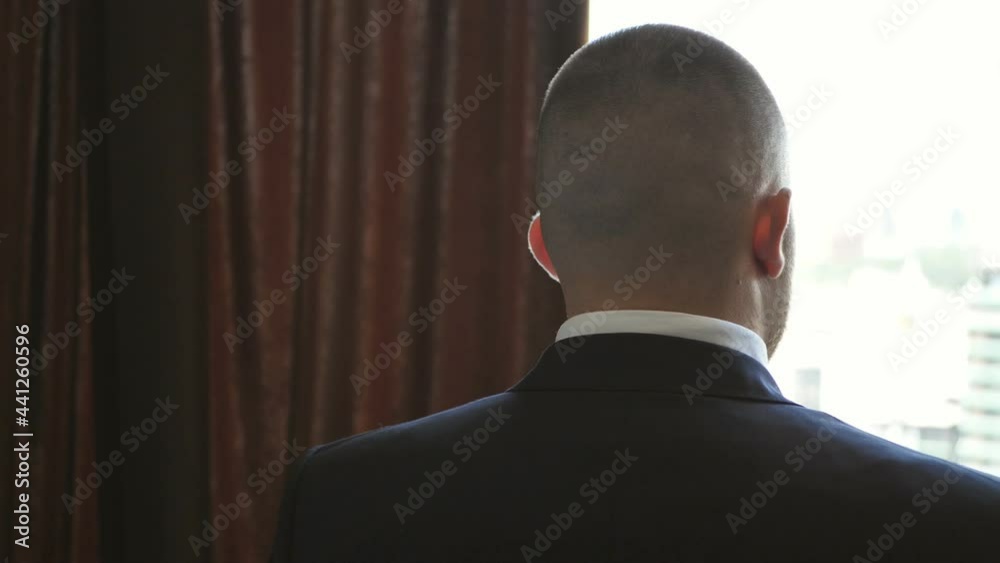 A young man put on his tuxedo jacket. Groom dresses for an event or wedding A young man put on his tuxedo jacket. Groom dresses for an event or wedding