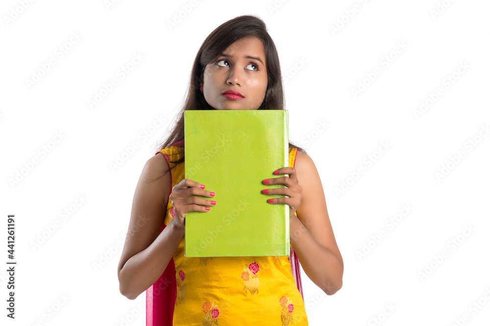 Pretty young girl holding book and posing on white background Pretty young girl holding book and posing on white background