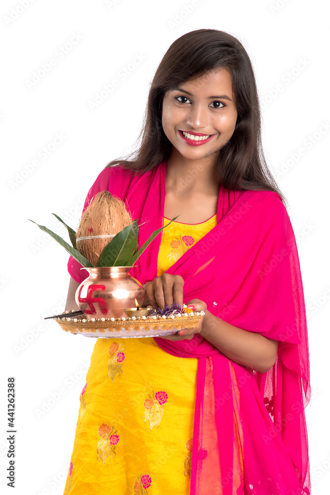 Indian girl holding a traditional copper Kalash with Pooja Thali, Indian Festival, copper Kalash with coconut and mango leaf with floral decoration, essential in Hindu Pooja. Indian girl holding a traditional copper Kalash with Pooja Thali, Indian Festival, copper Kalash with coconut and mango leaf with floral decoration, essential in Hindu Pooja.