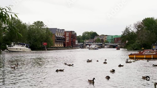 People having a good time on a small boats cruising down the River Thames on cloudy weekend photo