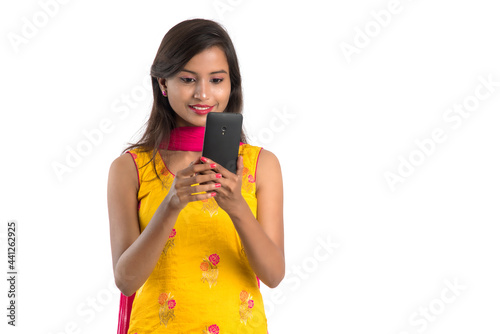 Young Indian girl using a mobile phone or smartphone isolated on a white background