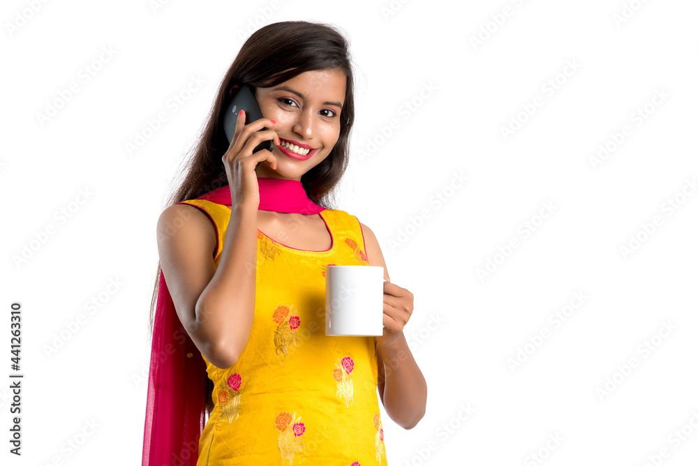 Pretty young girl calling on smartphone device while drinking tasty coffee or tea beverage Pretty young girl calling on smartphone device while drinking tasty coffee or tea beverage