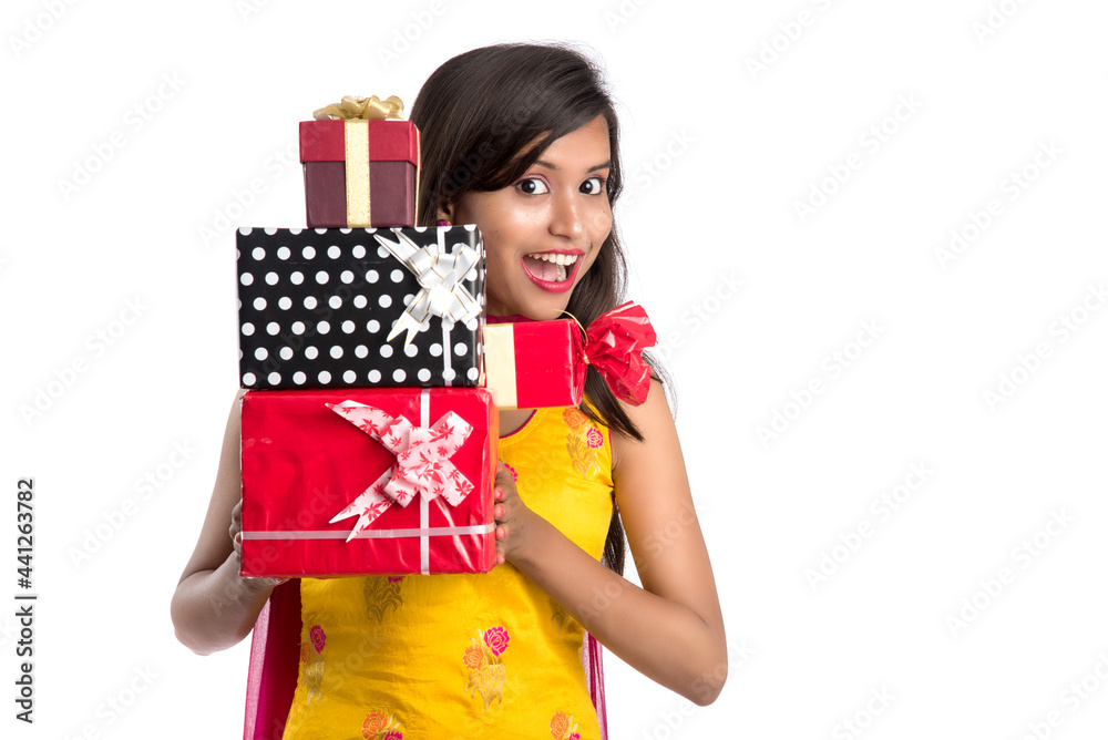 Portrait of young happy smiling Indian Girl holding gift boxes on a white background. Portrait of young happy smiling Indian Girl holding gift boxes on a white background.