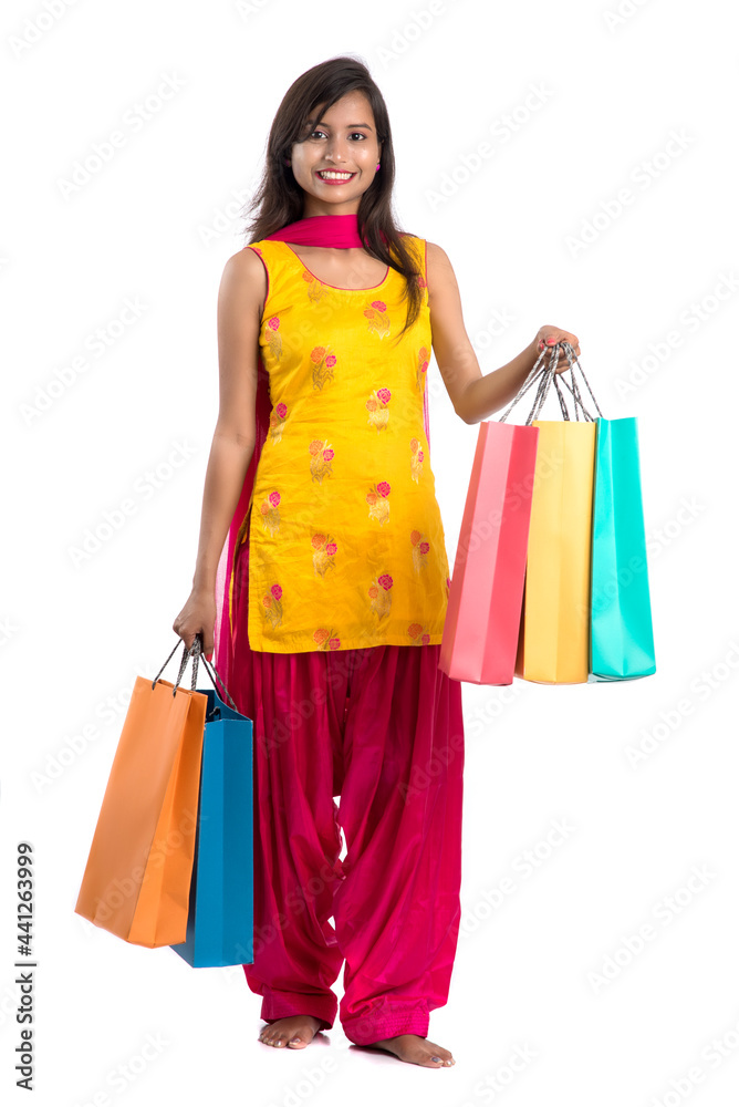 Beautiful Indian young girl holding and posing with shopping bags on a white background Beautiful Indian young girl holding and posing with shopping bags on a white background