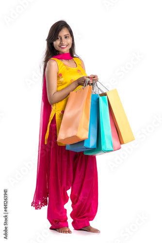 Beautiful Indian young girl holding and posing with shopping bags on a white background