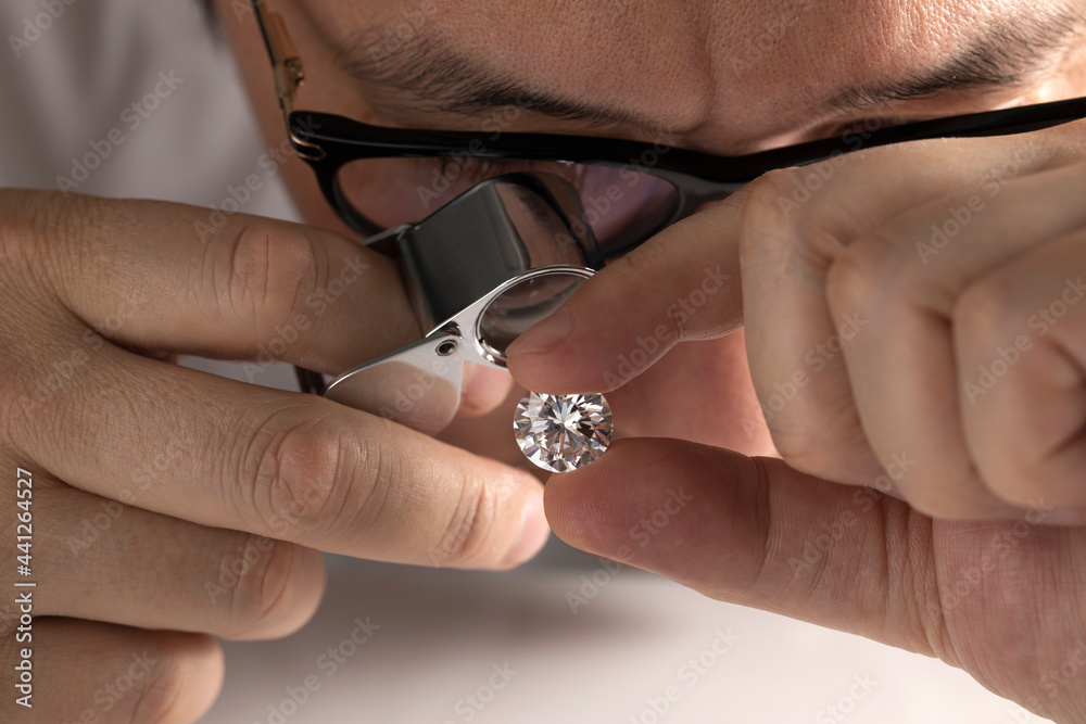 Close up of diamond dealer's hands evaluating diamond at international jewelry exhibition. High quality photo - obrazy, fototapety, plakaty 