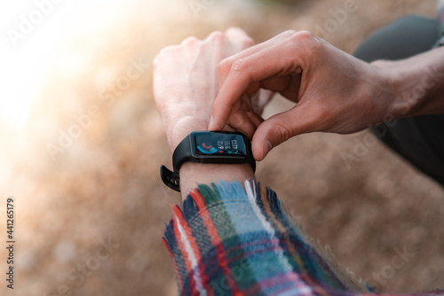 Hiker using heart rate monitor training running, smartwatch checking performance or GPS. Traveller looking at stopwatch. Technology for tracking activity.