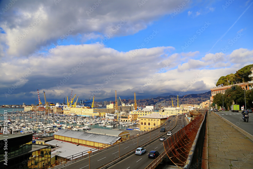 Genoa, Italy. Panoramic view of the city and the port of Genoa with its colored cranes and in the foreground the elevated road