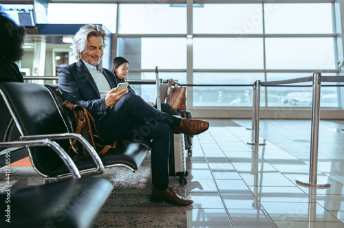 Foto Mature man waiting for flight at the airport lounge