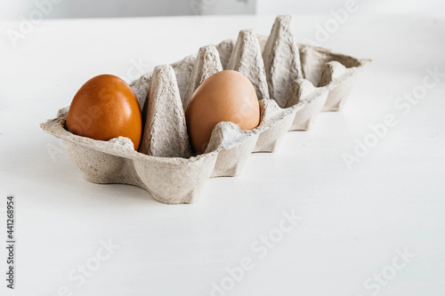 Minimalist organic food concept. Organic brown eggs inside and outsideof carton eco box photo