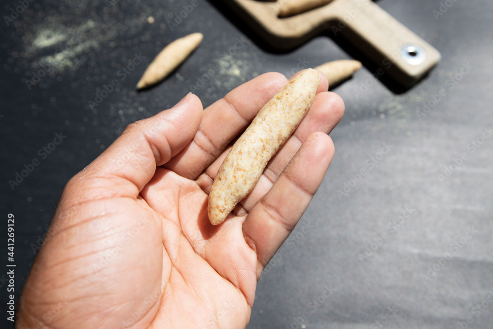Hand holding Jamaican Spinners dumpling. Dumpling made from whole wheat