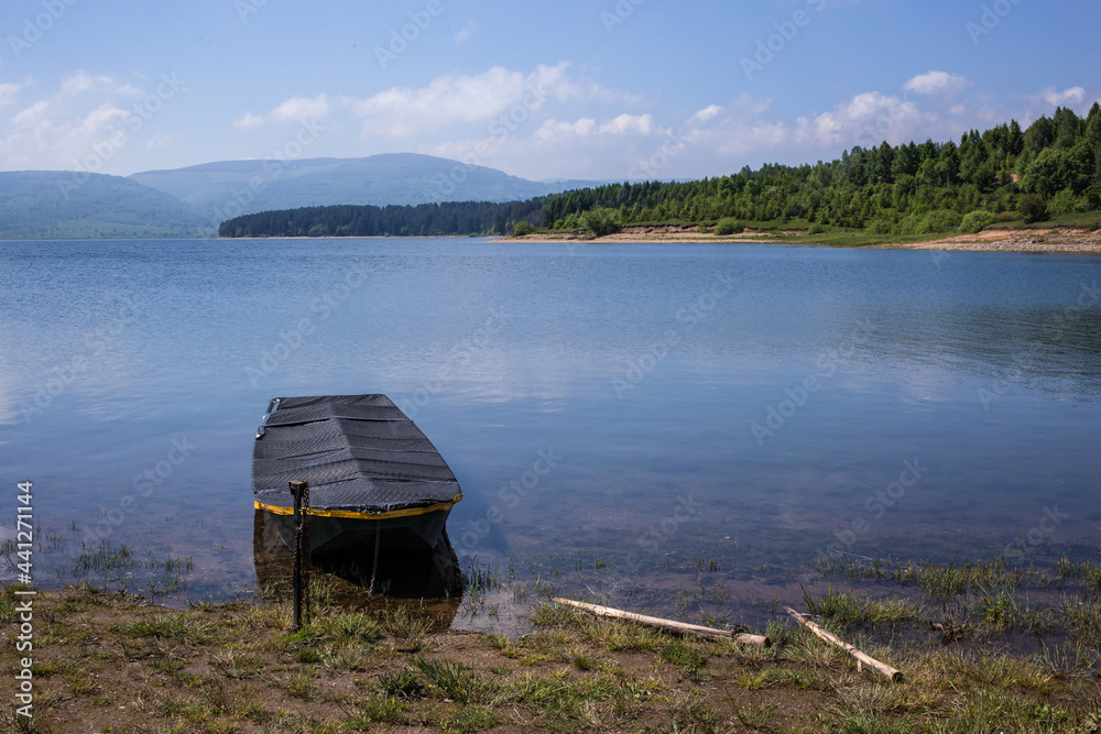 Boat on the lake shore. Calm, relax scenery. Vlasina lake, Eastern Serbia Boat on the lake shore. Calm, relax scenery. Vlasina lake, Eastern Serbia