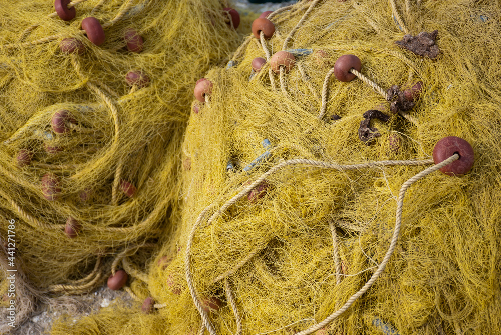 Astros Port, Peloponnese, Greece - June 24, 2021: Fishing nets drying at a picturesque fishing port. Astros Port, Peloponnese, Greece - June 24, 2021: Fishing nets drying at a picturesque fishing port.