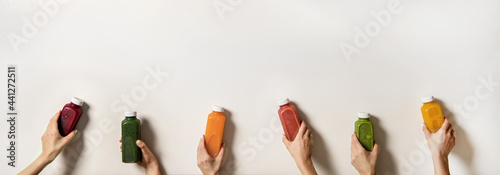 Human hands holding fresh juices in bottles, copy space photo