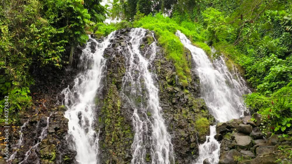 Aerial top view of jungle Waterfall in a tropical forest surrounded by green vegetation. Mimbalut Falls in mountain jungle. Philippines, Mindanao. Iligan City, Lanao del Norte. Aerial top view of jungle Waterfall in a tropical forest surrounded by green vegetation. Mimbalut Falls in mountain jungle. Philippines, Mindanao. Iligan City, Lanao del Norte.