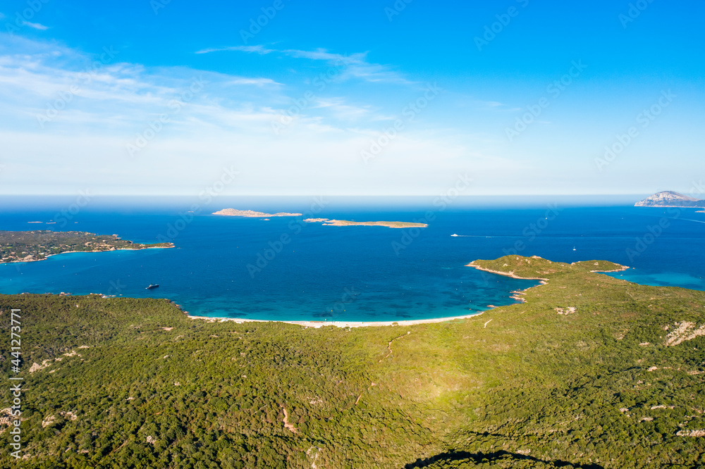 View from above, stunning aerial view of a green coastline with some beaches bathed by a turquoise sea. Liscia Ruja, Costa Smeralda, Sardinia, Italy.