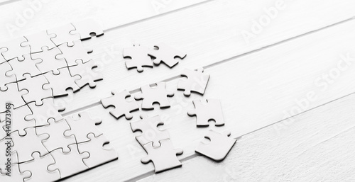 Pieces of empty jigsaw puzzle on white table photo