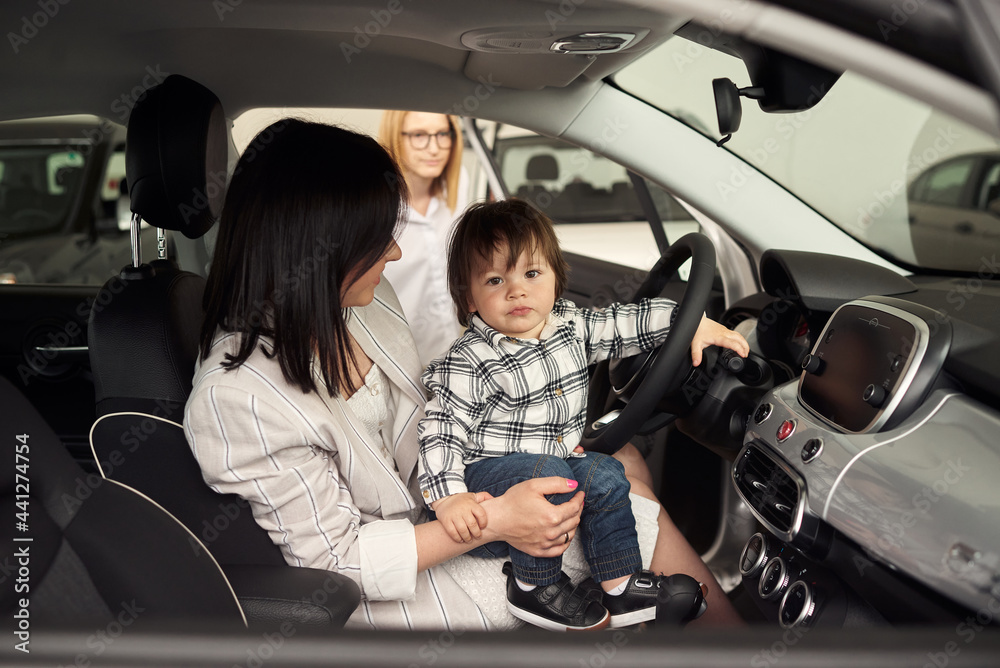 The young family chooses their first car. The young family chooses their first car.