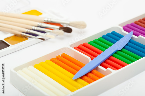 Colorful plasticine and watercolor paints as a school set for drawing.