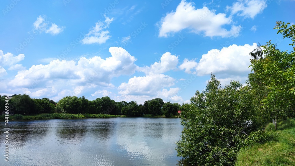 Landscape with a lake and clouds on the sky in the summer season Landscape with a lake and clouds on the sky in the summer season