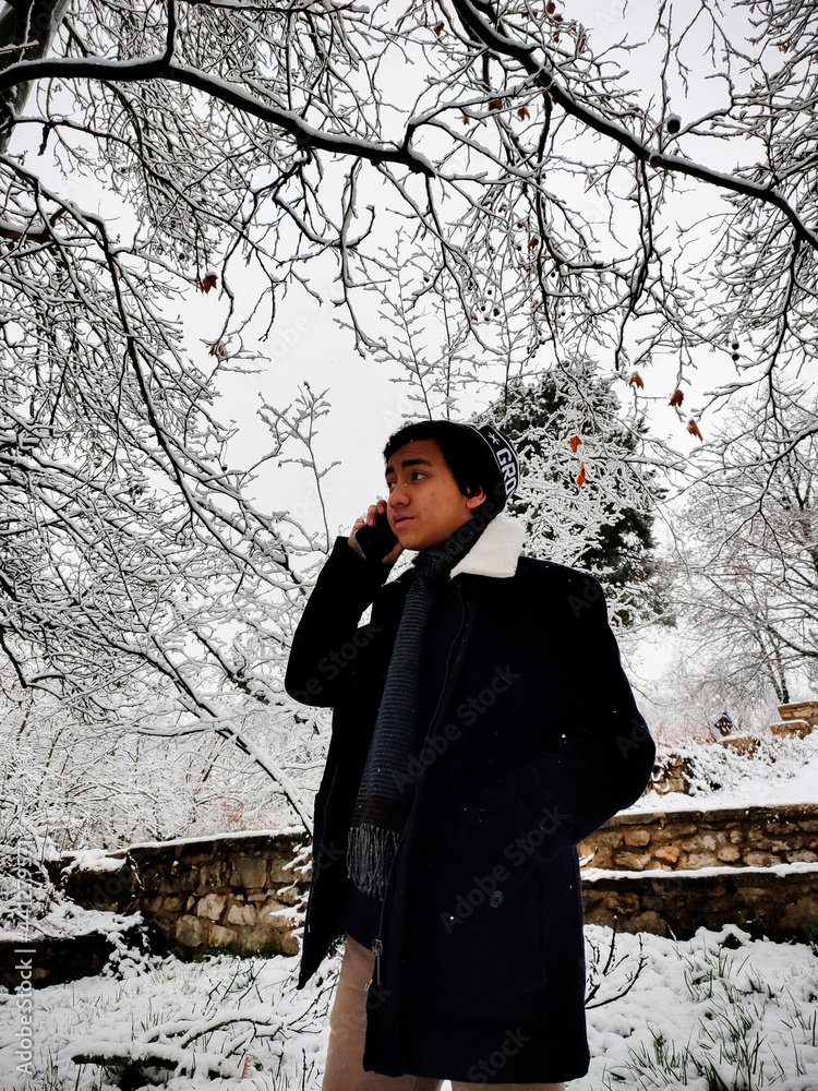 an indonesian young man at ifrane's park during winter season. ifrane, morocco an indonesian young man at ifrane's park during winter season. ifrane, morocco