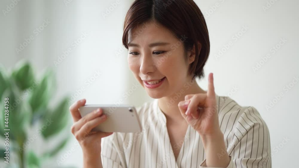 スマートフォンで手話の指文字を勉強する女性
