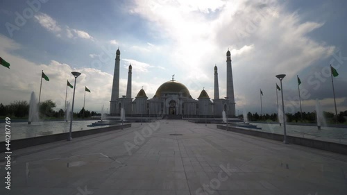 Beautiful Fountains Over Landscape Of Famous Mosque Against Cloudy Sky - Ashgabat, Turkmenistan photo