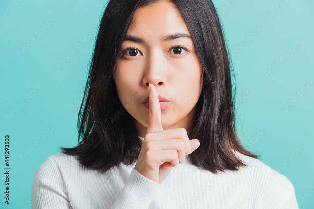 woman holding index finger on her mouth lips woman holding index finger on her mouth lips