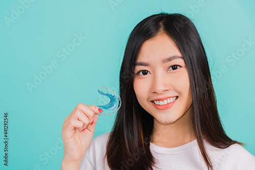 woman smiling holding silicone orthodontic retainers for teeth photo