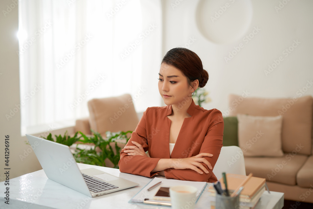 Beautiful stressed young office worker sitting at desk holding head because of pain in office Beautiful stressed young office worker sitting at desk holding head because of pain in office