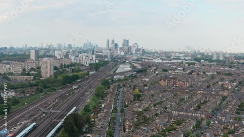 Circling drone shot of busy London train tracks rail network with city skyline in the background photo