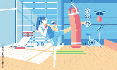 young girl doing kickboxing exercise at gym, with many gym equipment in the background