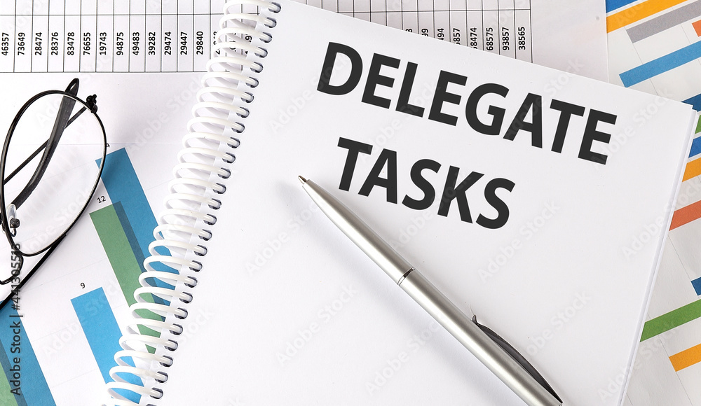 DELEGATE TASKS , pen and glasses on the chart, business concept DELEGATE TASKS , pen and glasses on the chart, business concept