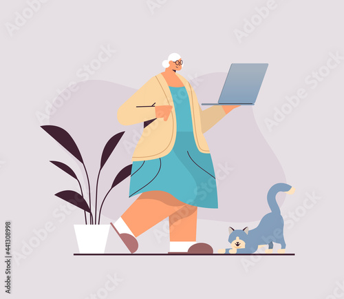 senior woman using laptop grandmother relaxing at home social media network concept full length