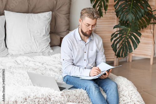Young man studying online a...