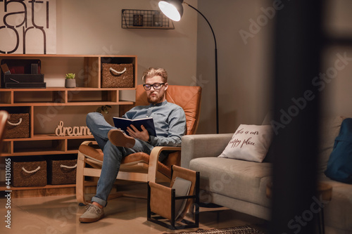 Young man reading book whil...