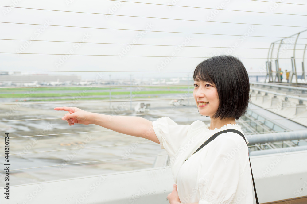 空港の展望デッキから景色を眺める女性