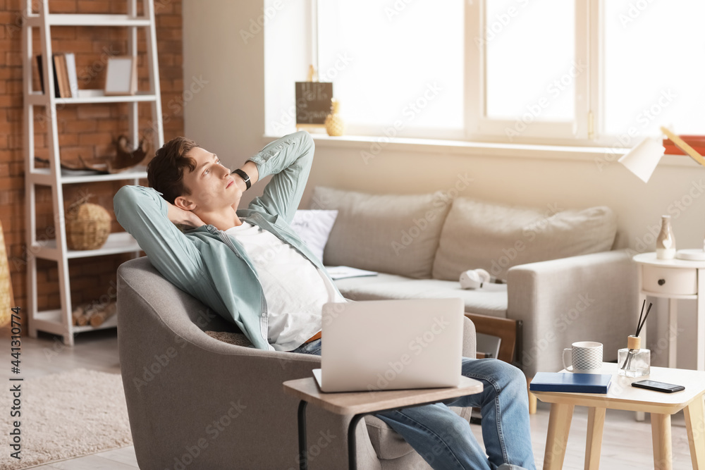 Young man relaxing in armchair at home