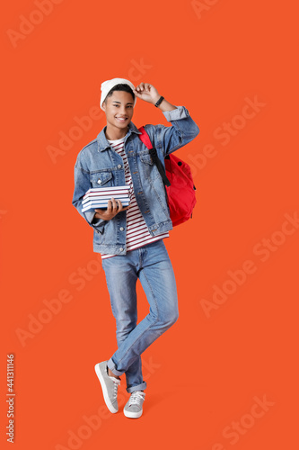 Male African-American student with books on color background © Pixel-Shot