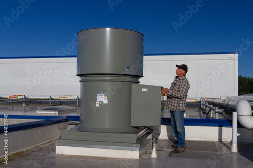 man inspecting exhaust fan