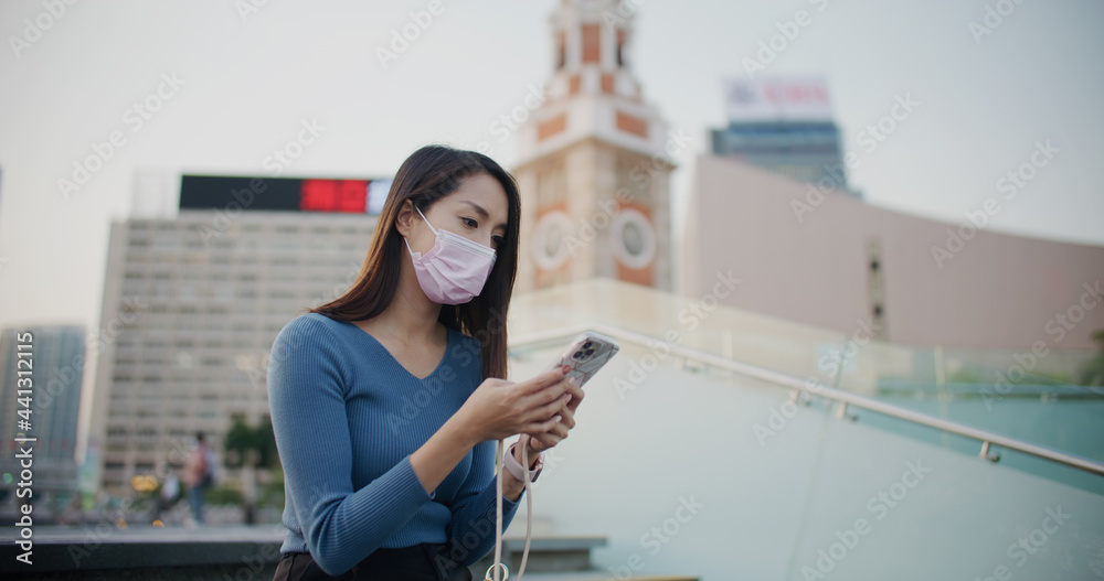 Fototapeta premium Woman wear face mask and use of mobile phone at outdoor
