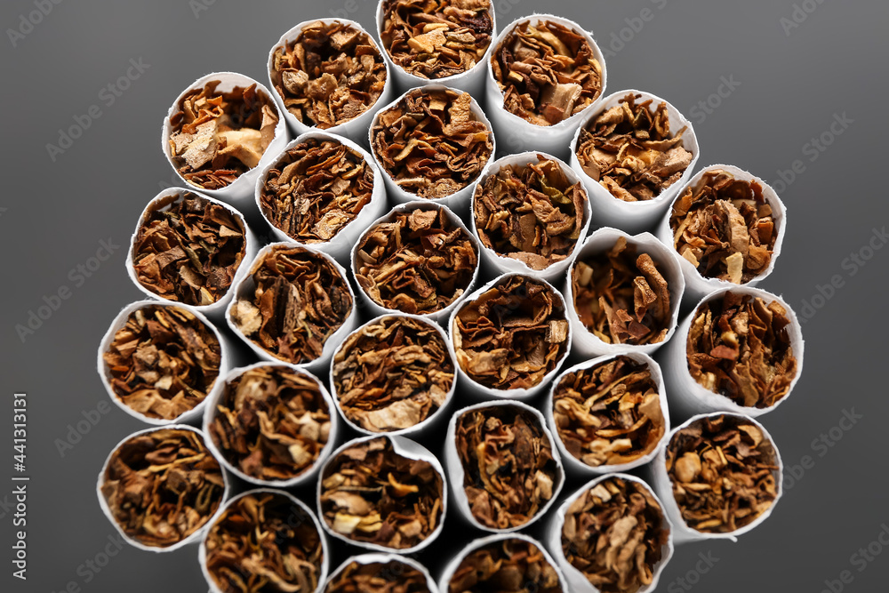 Many cigarettes on dark background, closeup Many cigarettes on dark background, closeup