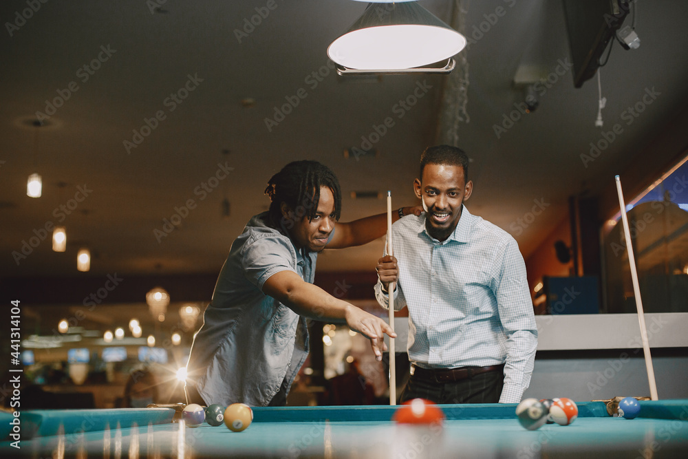 Φωτογραφία Men playing billiards in a club