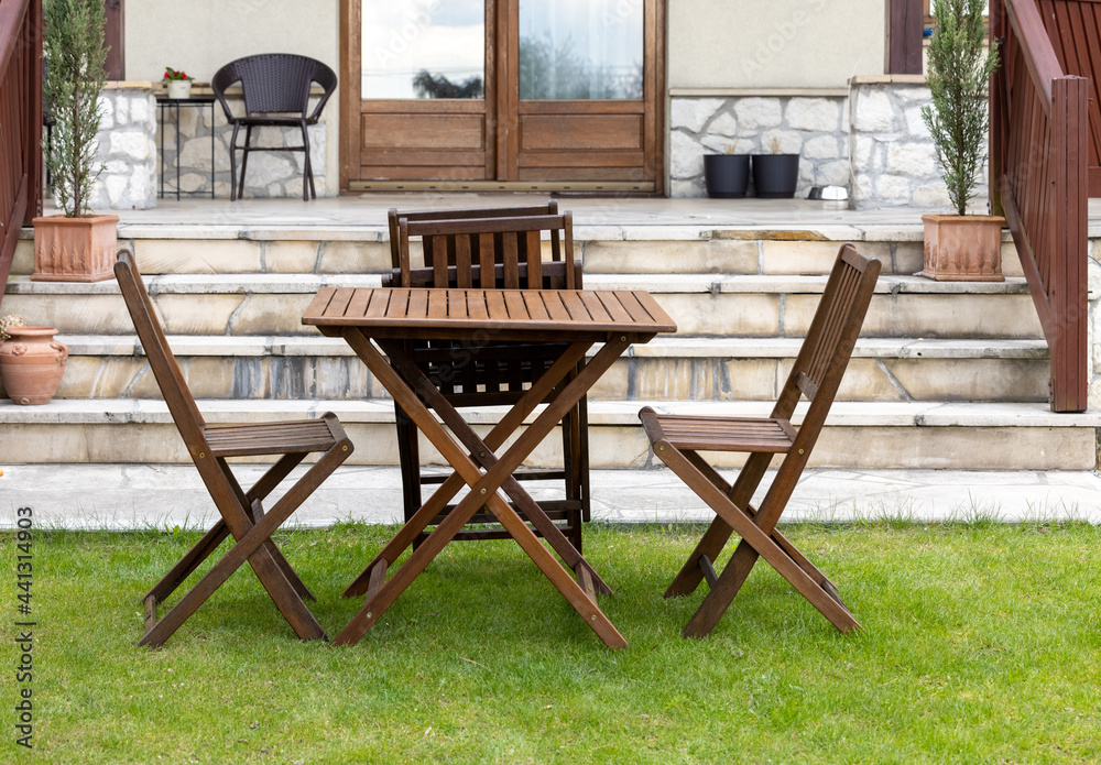 wooden table and chairs on the garden lawn