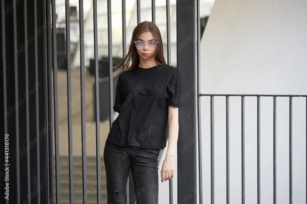 Woman or girl wearing black blank cotton t-shirt with space for your logo, mock up or design in casual urban style Woman or girl wearing black blank cotton t-shirt with space for your logo, mock up or design in casual urban style